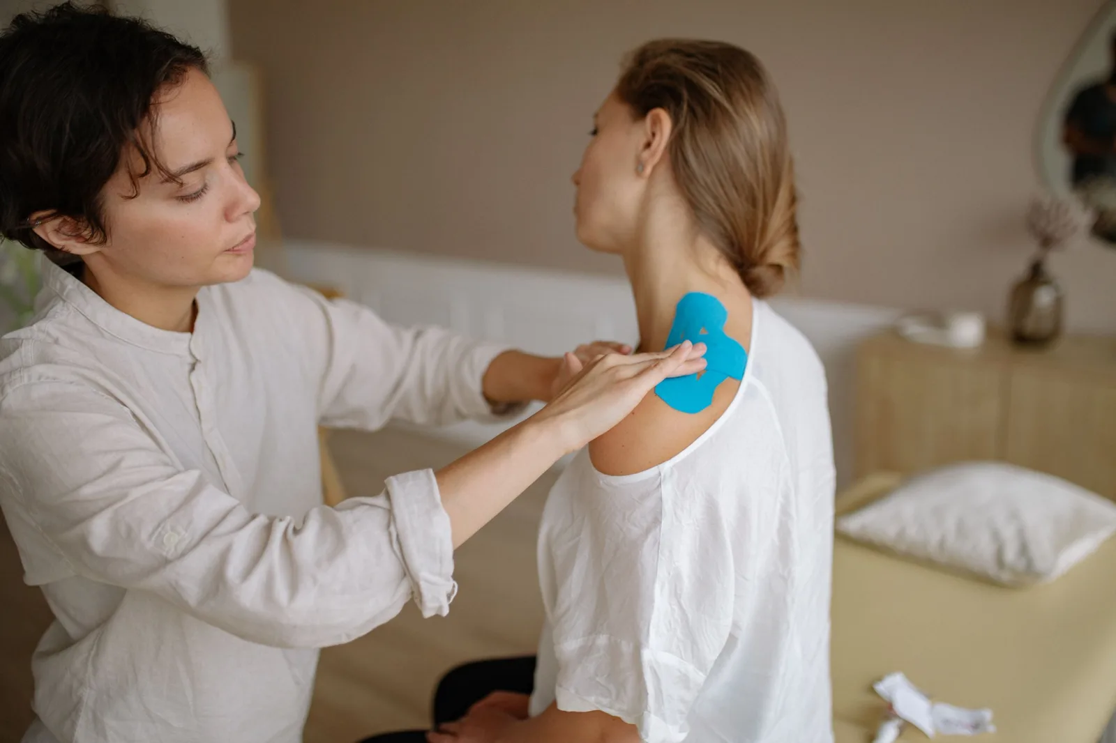 Physiotherapist treating a patient's shoulder in a clinic
